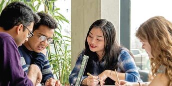 Diverse group of 4 students studying together at a table