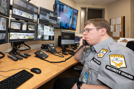 Security guard sitting in front of many monitors