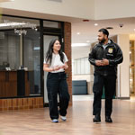 security guard with a student walking down a hall