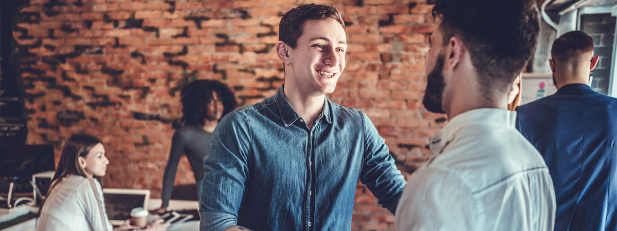Young man shaking employer's hand in hipster office