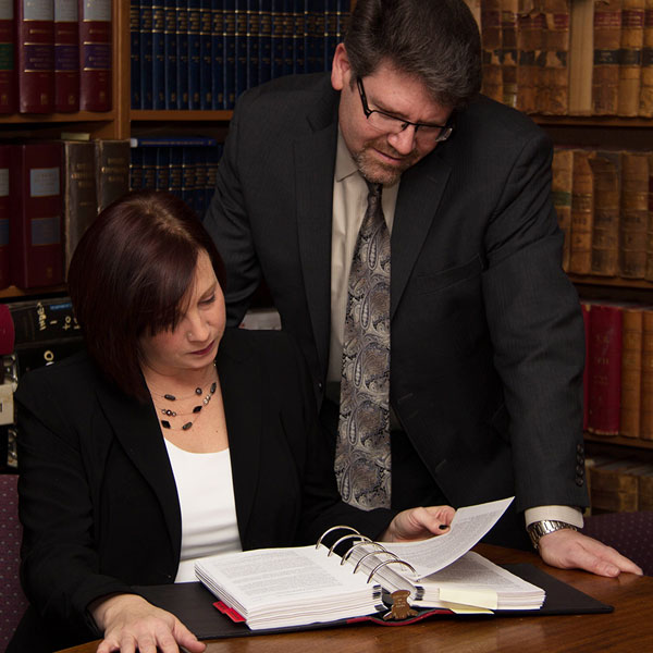 A lawyer reviews paperwork with a co-op student