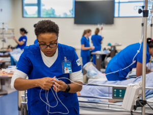 A nursing student running an IV line.