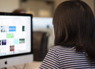 Student looking at Mac with graphic design program on it