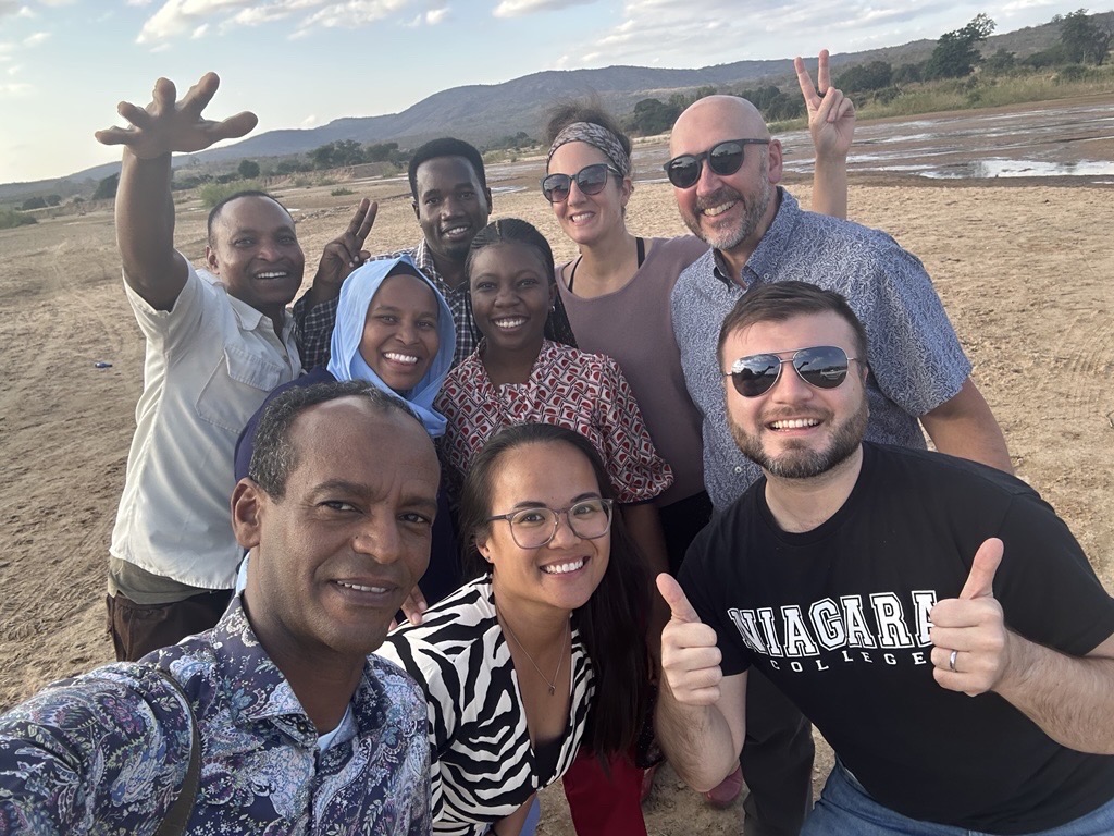 The ESP team from Niagara College International and local partners in Tanzania caught in flooding and crossing a river on foot.