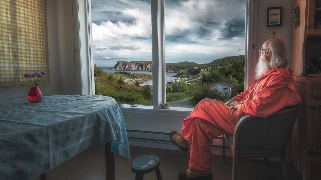 An older man looking out a window