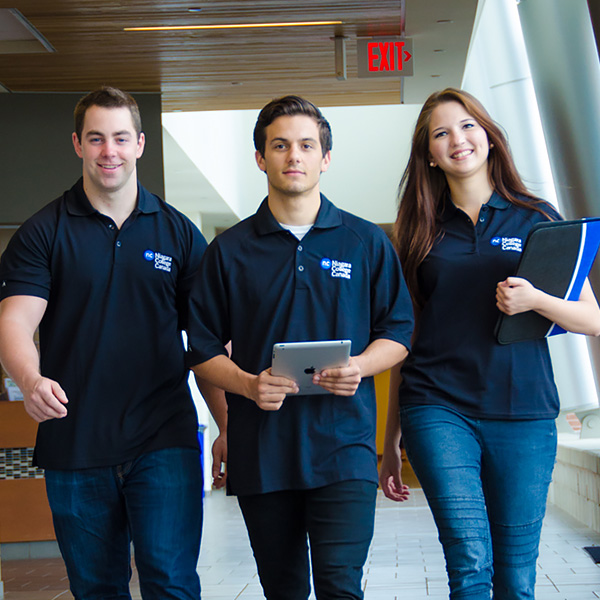 Three Student Recruiters walking in hallway wearing NC shirts