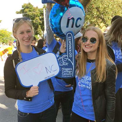 Students wearing NC shirts and holding NC signs and a balloon