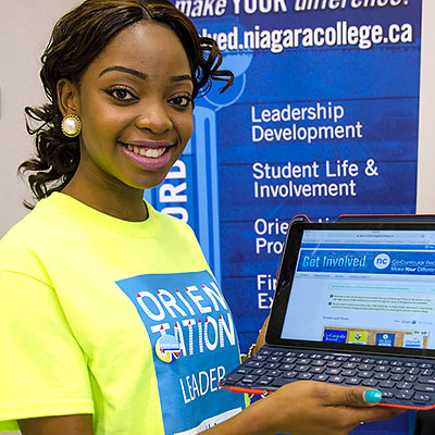 Student Orientation Leader displays the Get Involved website on a laptop