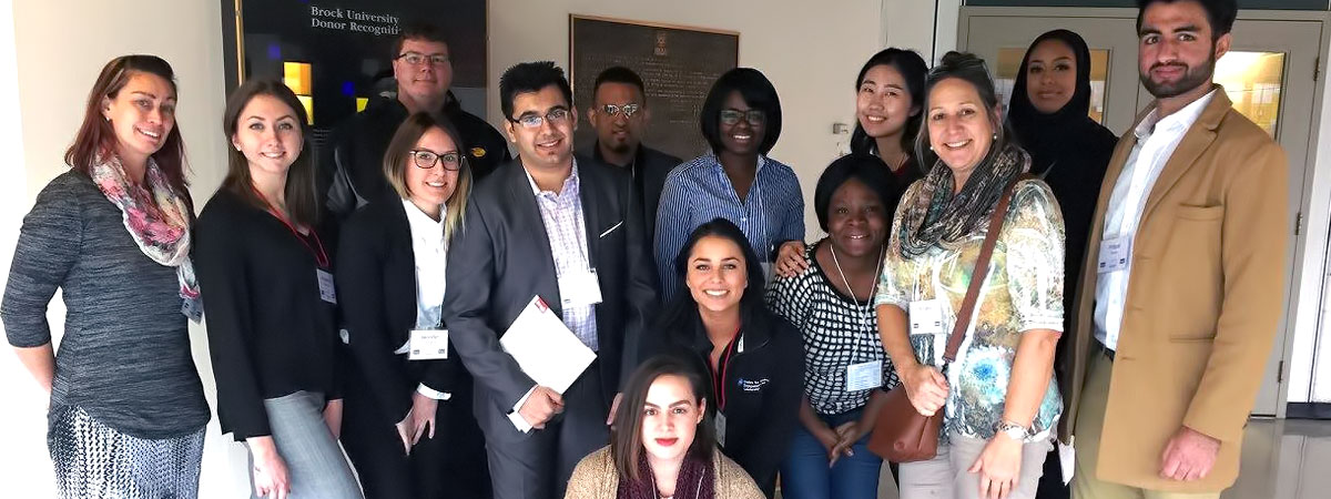 A diverse group of LEAD students holding papers and posing together in a group
