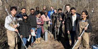 Group of students posing in a forest.