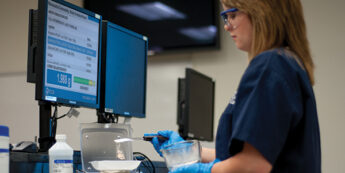student working in classroom measuring out pharmacy ingredient
