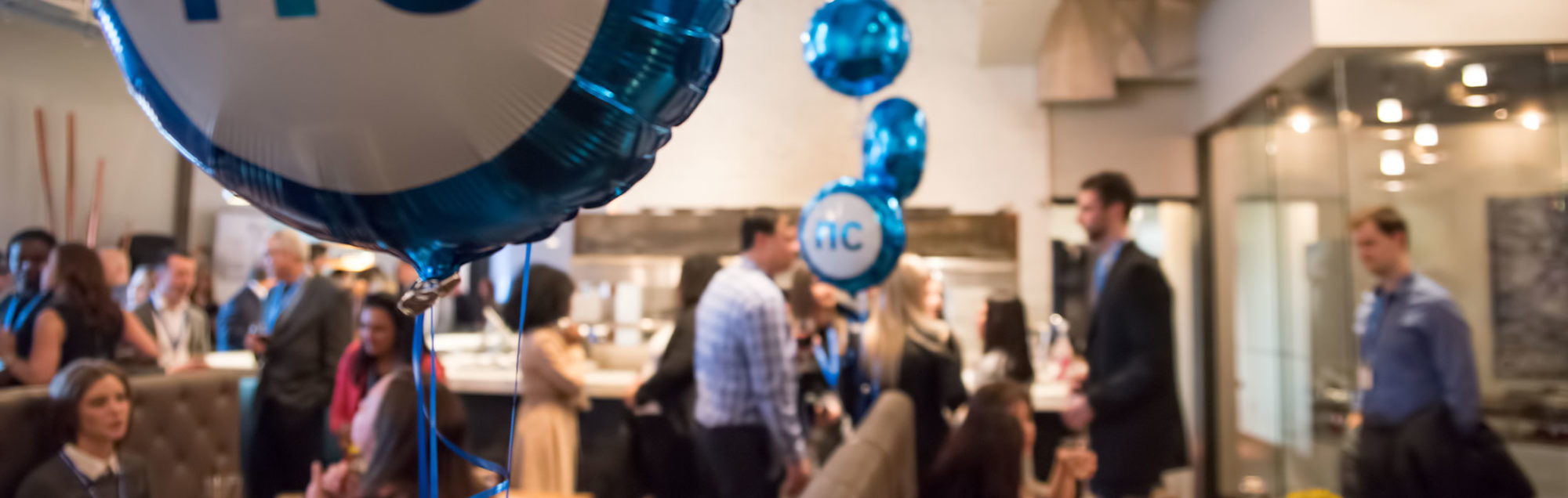 Retirees and former employees gather at a restaurant with NC balloons