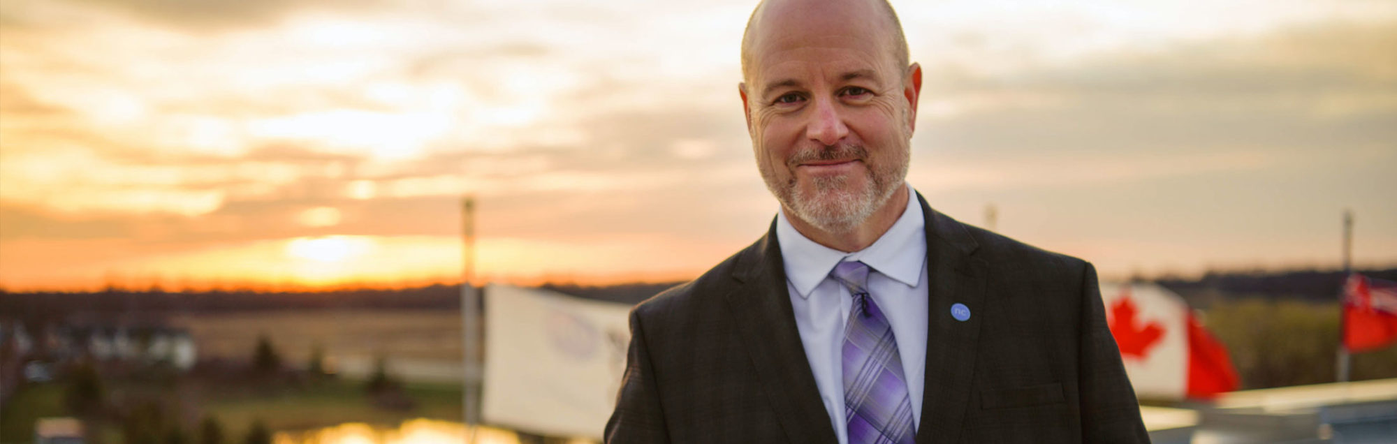 Sean Kennedy standing in front of NC tower with sunset
