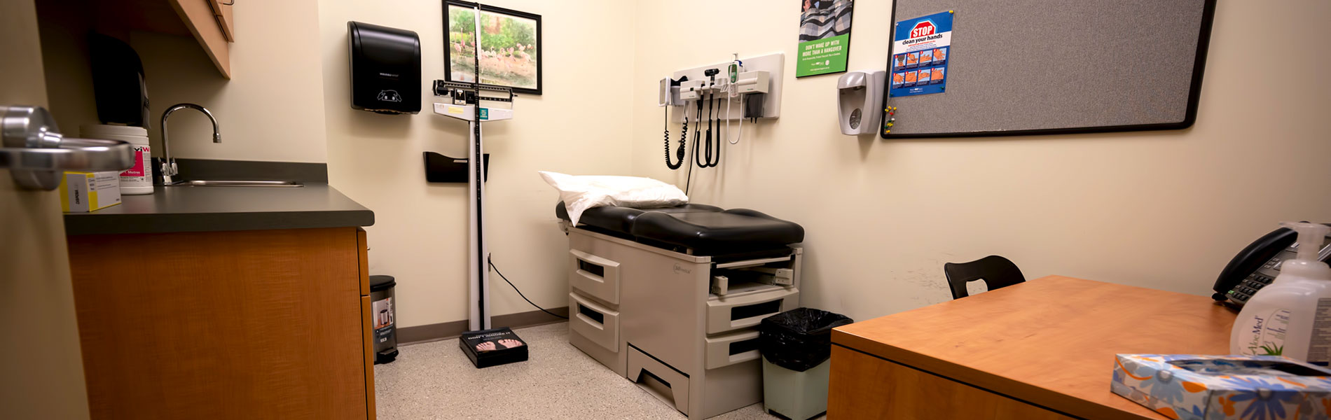 A health services doctor's office with a bed, scale and other implements