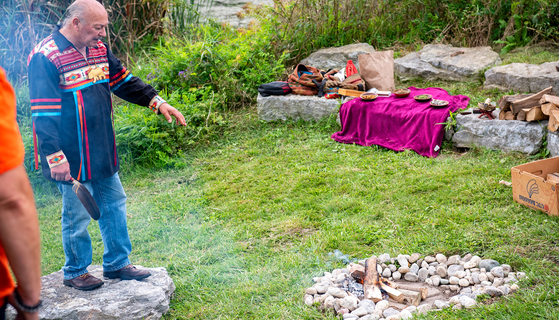 Elder Dave standing near a fire in the NOTL indigenous garden