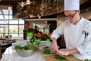 A chef from the CFWI cuts up herbs in Benchmark Restaurant