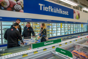 Coach Avi Hollo, team captain Ben Lillico, coach Olaf Mertens and team member Megan Proper shop in the frozen food section.