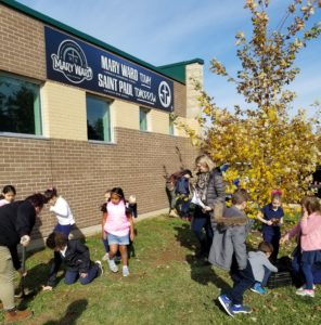 Grade two and grade four students from Mary Ward elementary school planting daffodils.