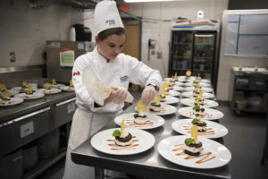 A first-year Culinary student preparing the chocolate chip meringata desserts