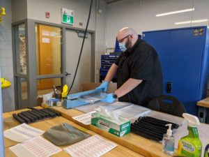 Brian Klassen assembling face shields in research lab