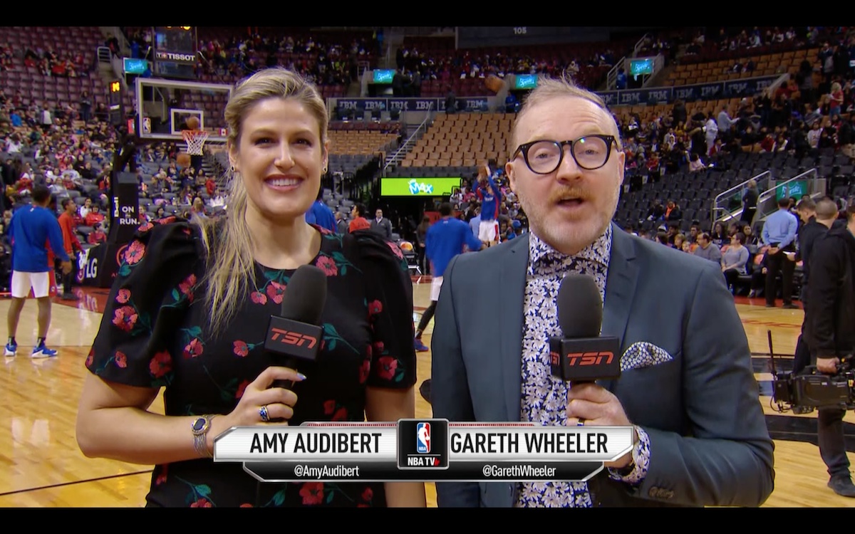 Amy Audibert stands on the sidelines of a basketball court with Gareth Wheeler, reporting for TSN.