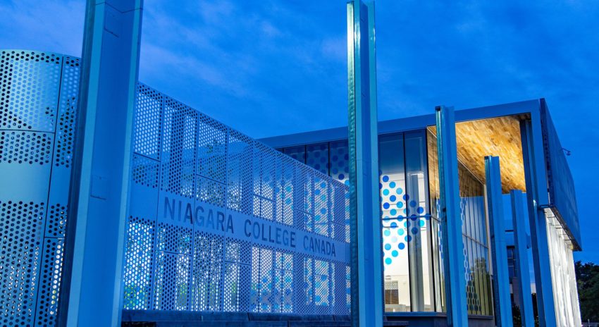 An exterior night time photo of the Niagara College Student Commons building at the Welland Campus