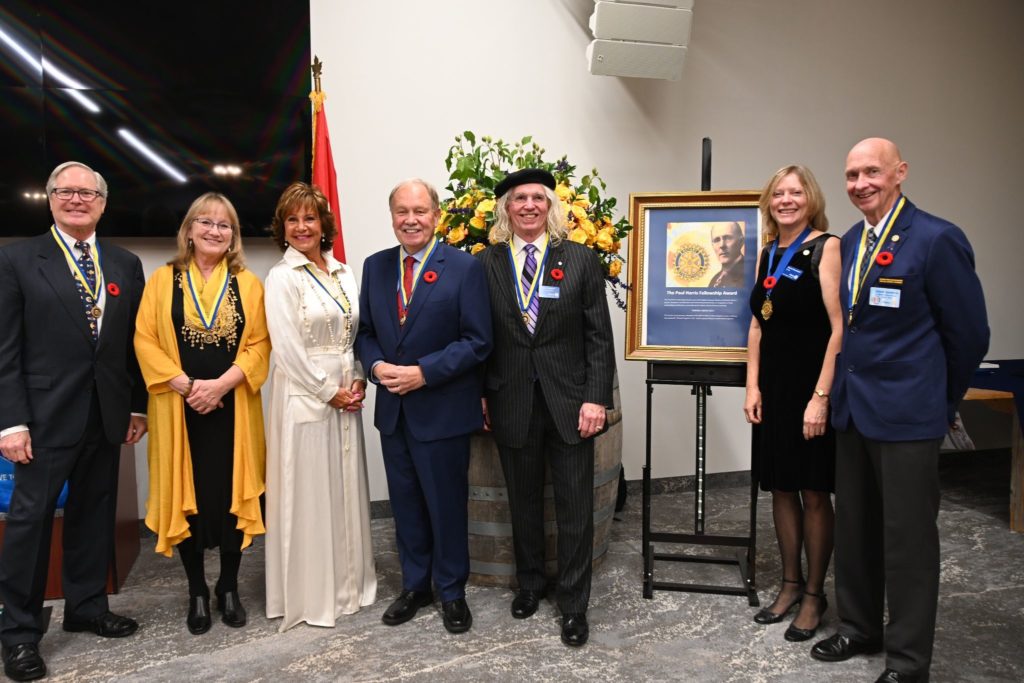 a group of award recipients stand side by side wearing dress attire and medals around their necks