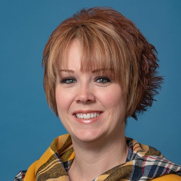 a woman with short red hair smiles at the camera