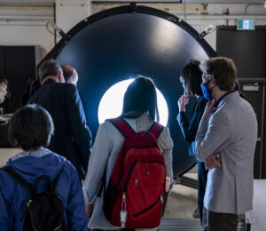 a group of people face a large sphere-like light source