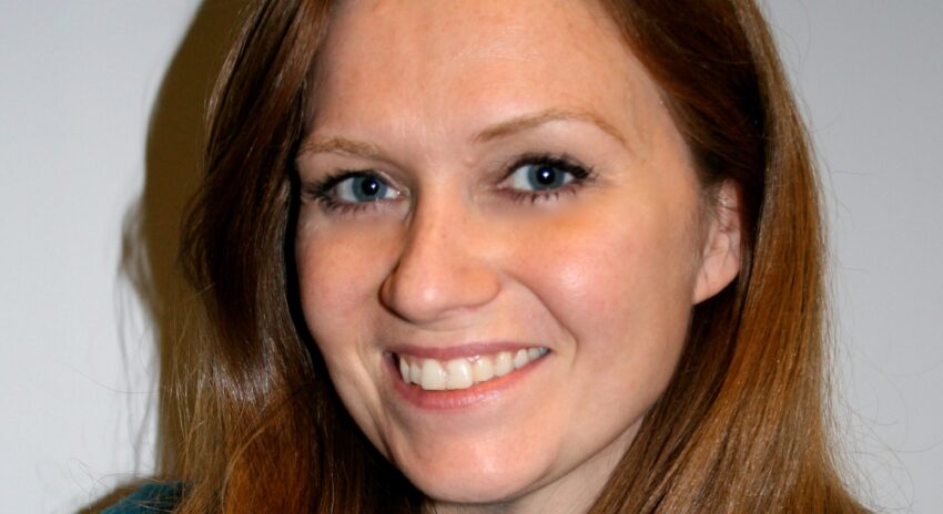 woman with long, red hair wearing a green shirt