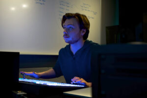a student focuses in a broadcasting control room