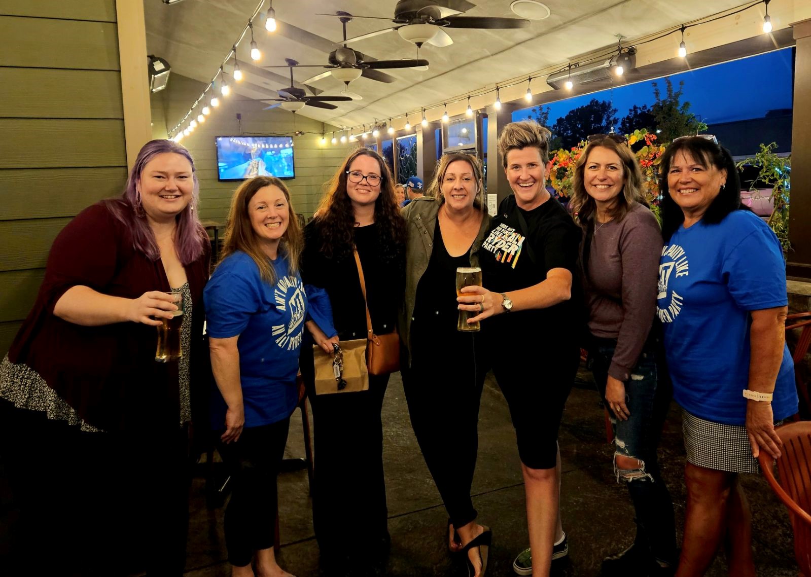 a group of seven women pose for a photo at a restaurant patio