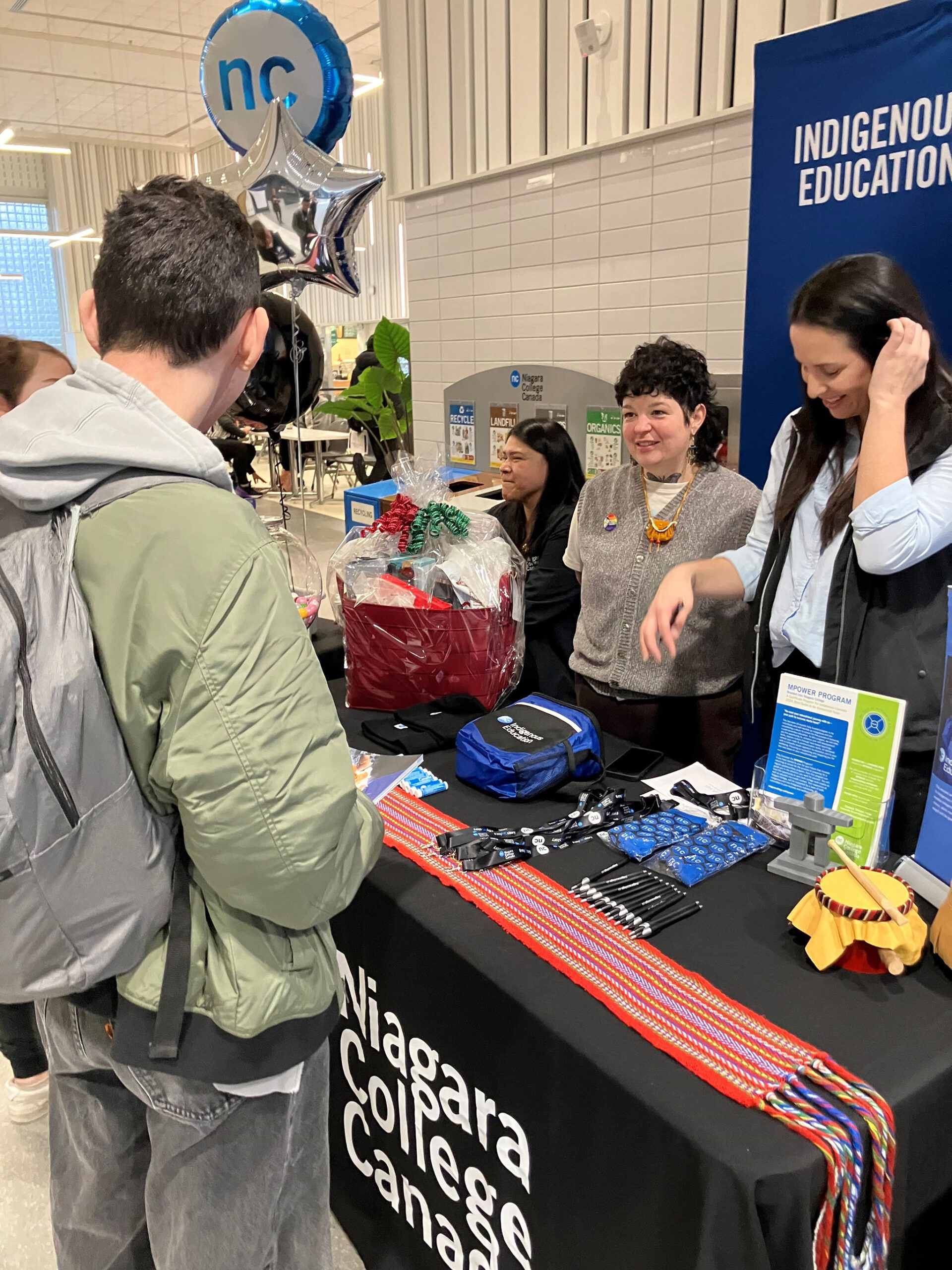 college staff speak with students at an information table
