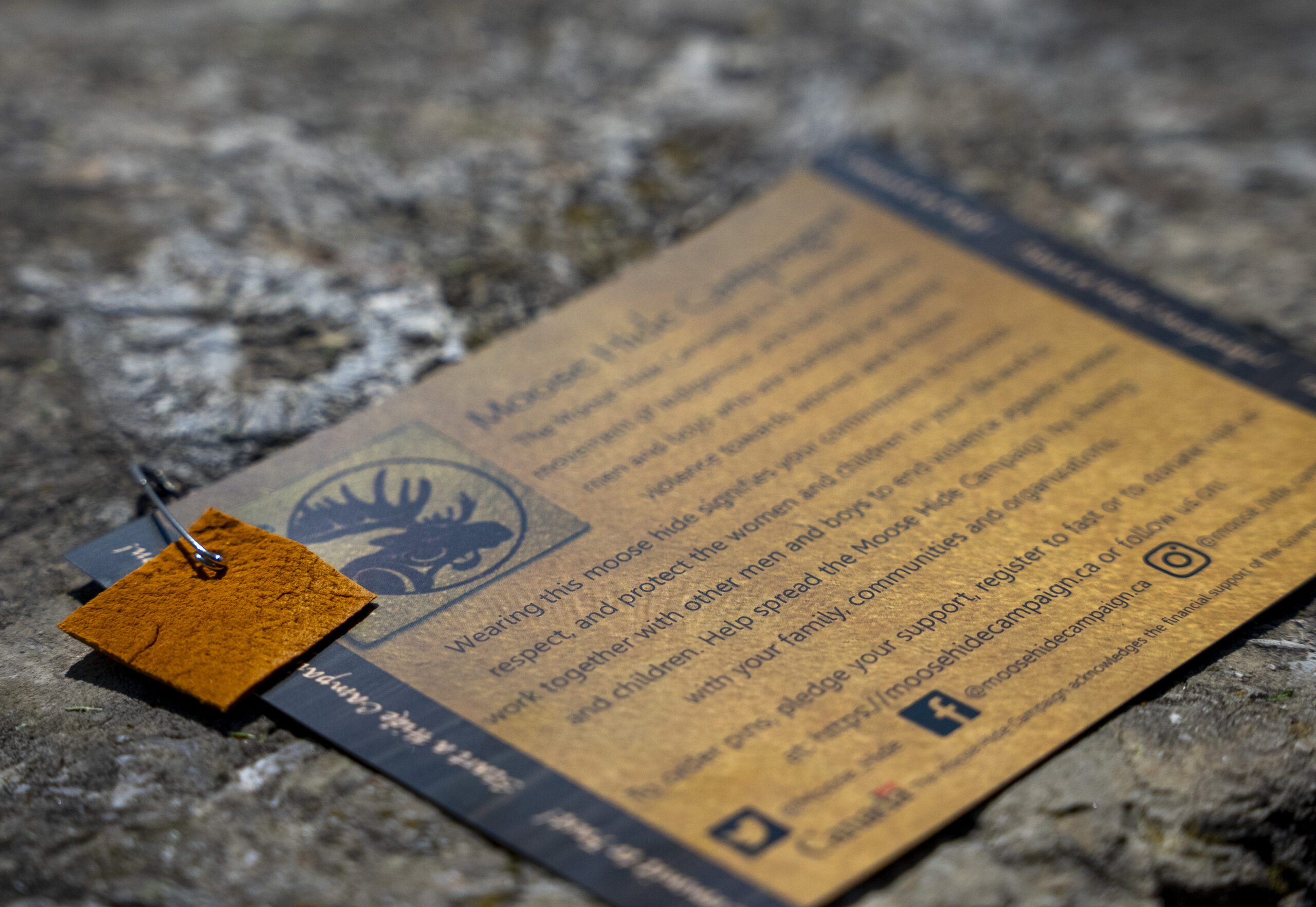 a moose hide pin with attached informational card