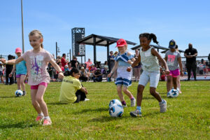 young girls play soccer on a sports field