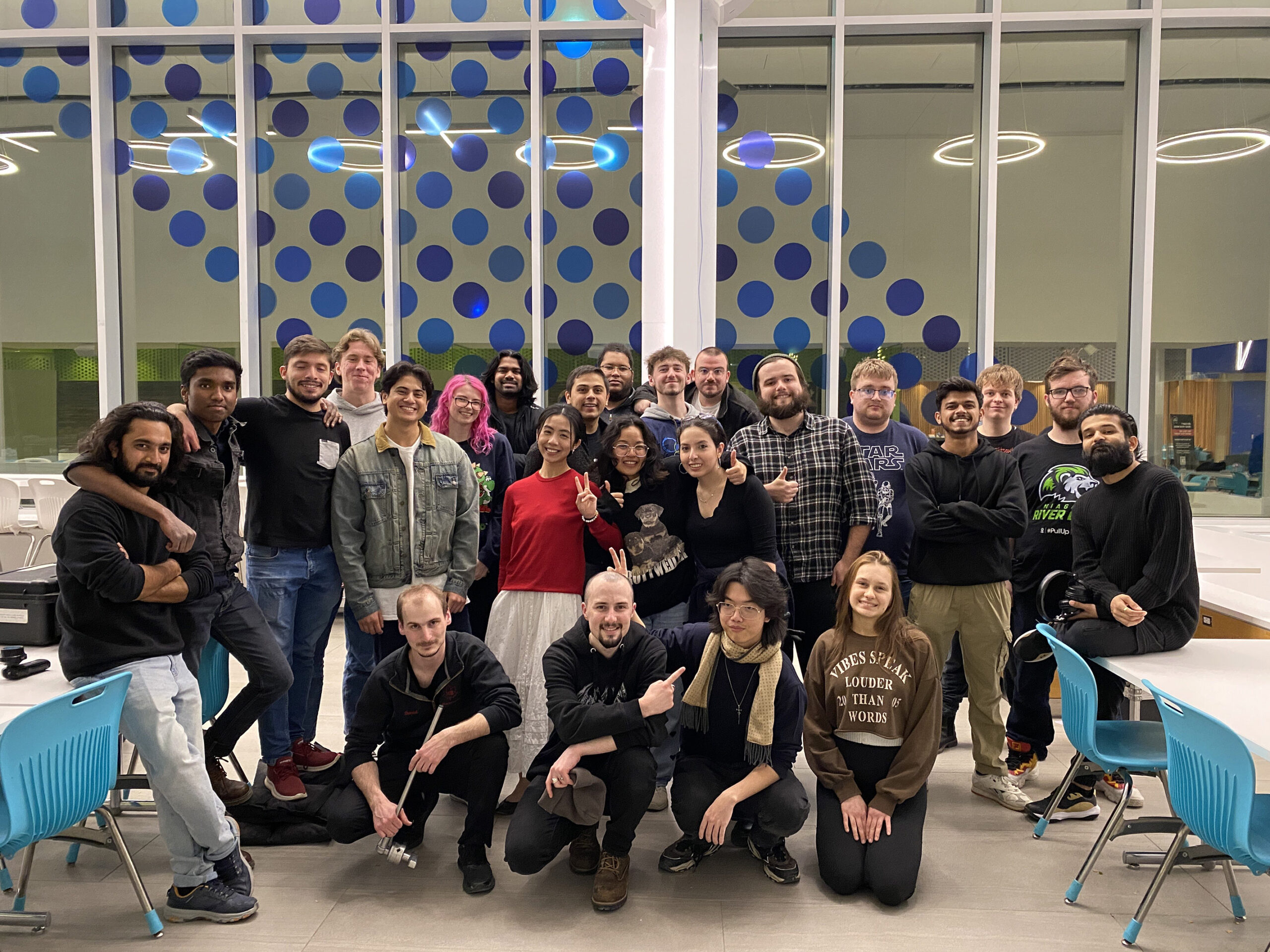 a large group of students pose for a photo in a school cafeteria