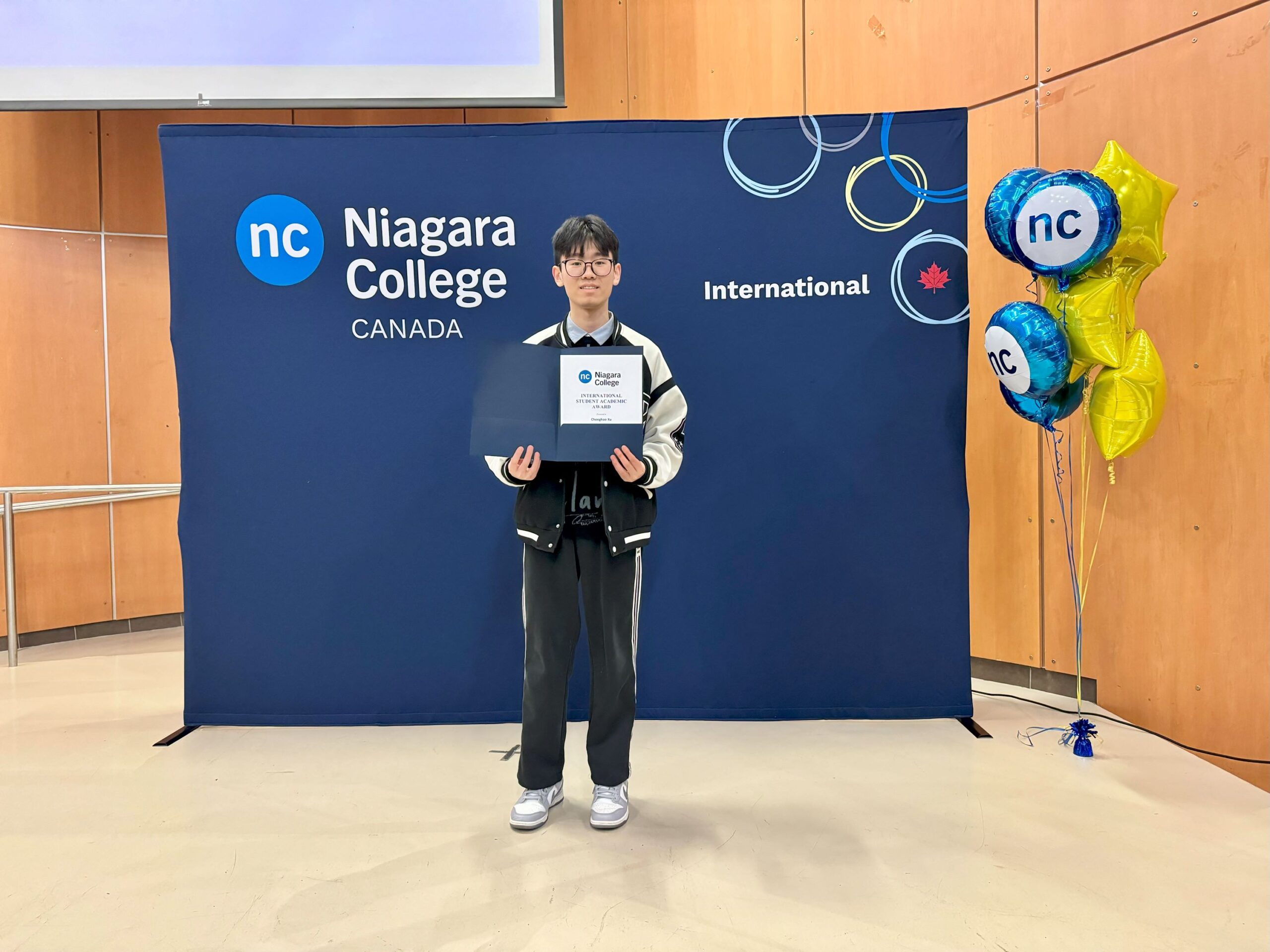 a student holds up an award certificate