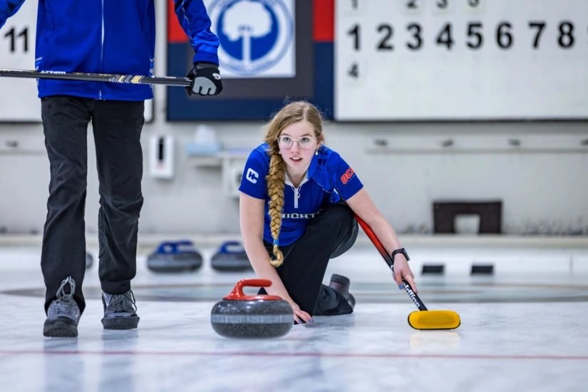 a curler prepares for her shot on the ice
