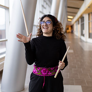 Student joyously throwing drumsticks in the air