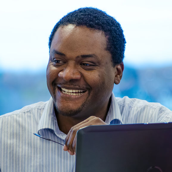 Man laughing sitting in front of laptop