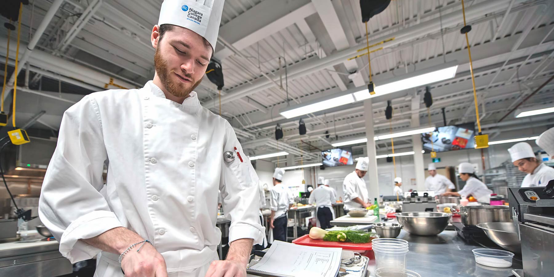 Student chef chops vegetables in kitchen classroom