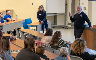 President Sean Kennedy speaking to a group of open house attendees during an information session.