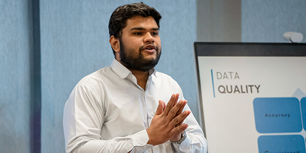 Male student presenting a data analytics project.