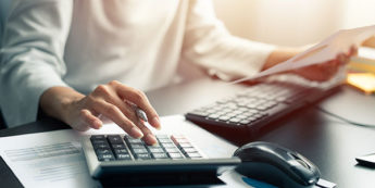 Person typing on a calcuator