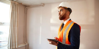 Home inspector wearing safety vest and hard hat