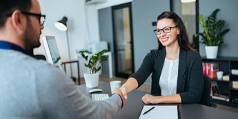 Woman shakes hand of employee