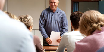 A teacher standing in front of a class of mature adults