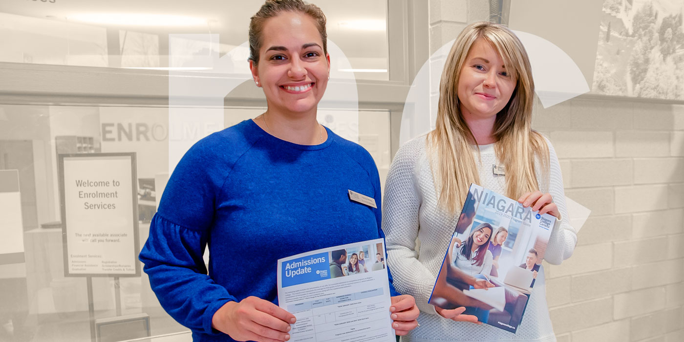 Two NC staff wearing NC shirts and holding Admissions flyers