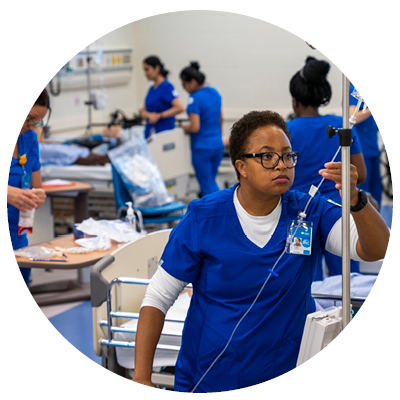 Nursing student inspects the tubing on an IV line.
