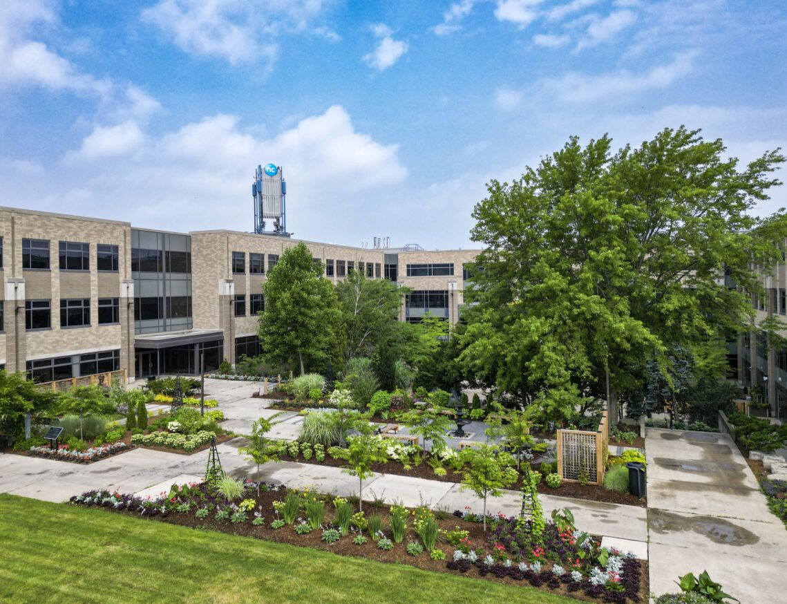 Courtyard and building at Niagara College DJP campus with trees in bloom.